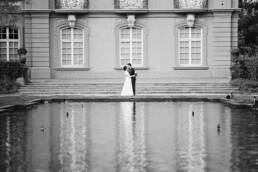 Hochzeitsfoto eines Brautpaares in Schwarz Weiß mit Wasserspiegelung im Palastgarten Trier